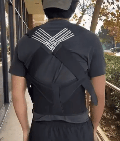 Man wearing a posture corrector while walking outside, demonstrating support for improved posture and back pain relief.
